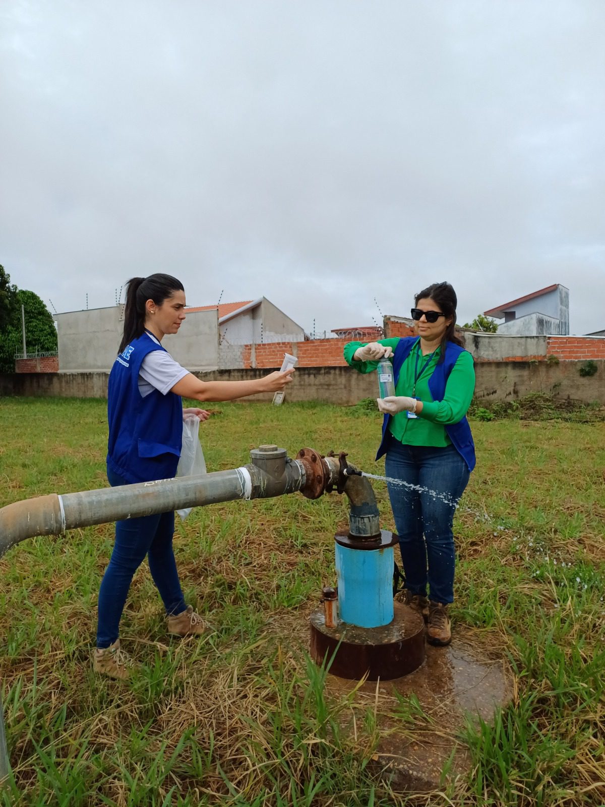 A engenheira Camila e Juliene realizando coleta de água para analises